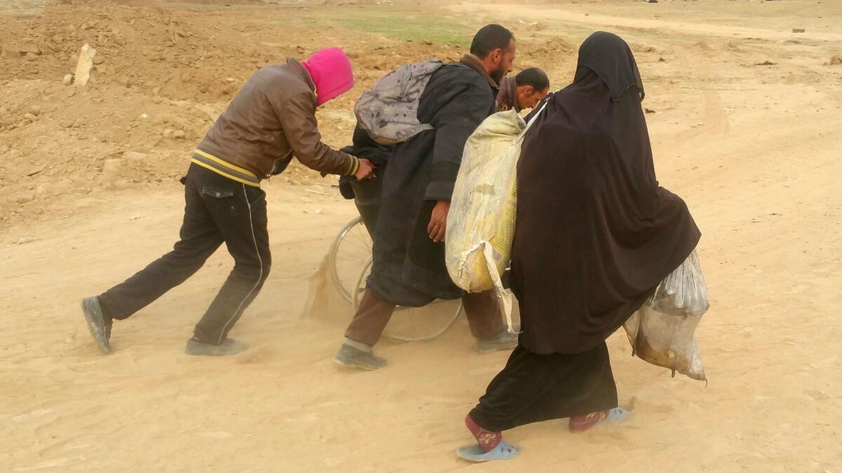 A family makes its escape out of the Al-Maamoun neighborhood in western Mosul.