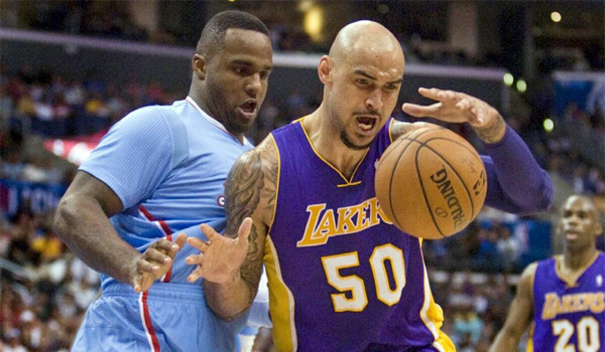 Robert Sacre, right, boxes out the Glen Davis, left, while grabbing a rebound during the first half of the Lakers' loss to the Clippers, 120-97, on April 6.