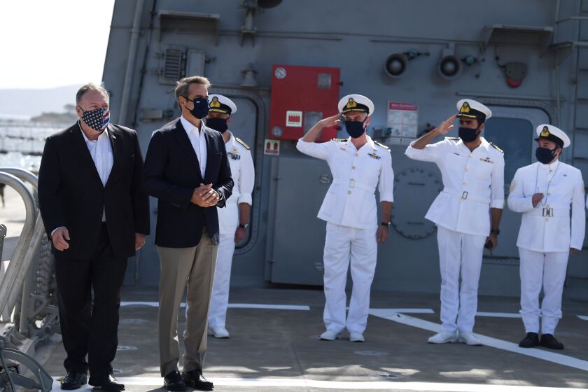 US Secretary of State Mike Pompeo, left, arrives with the Greek Prime Minister Kyriakos Mitsotakis on the Greek frigate Salamis during their visit to the Naval Support Activity base at Souda, the foremost US naval facility in the eastern Mediterranean, on the Greek island of Crete, Tuesday, Sept. 29, 2020. Pompeo visited a U.S. naval base at Souda Bay on the southern Greek island of Crete Tuesday, ahead of a meeting with Greece's prime minister on the second day of his trip to the country. (Aris Messinis/Pool viaAP)