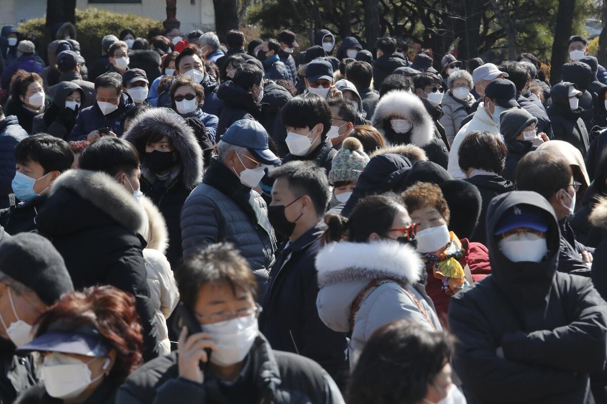 A crowd of people wearing face masks in Seoul.