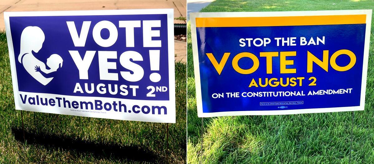  A vote yes yard sign and a vote no yard sign stuck into grass   