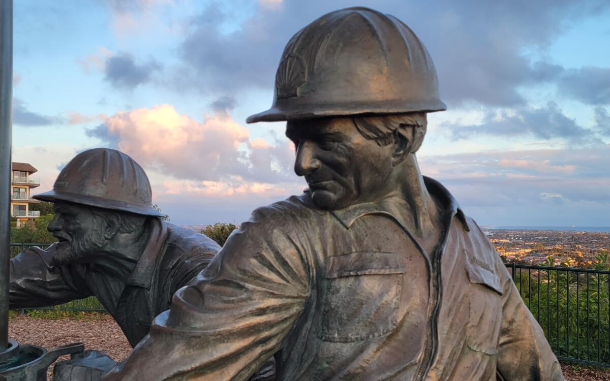 A statue of oil workers on Signal Hill overlooking Long Beach, where there's a long history of oil drilling.
