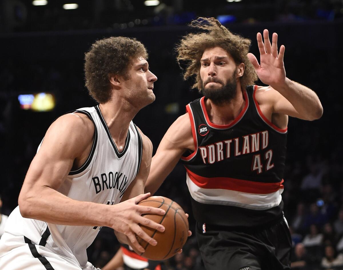 Nets center Brook Lopez goes to the basket against his twin brother, Trail Blazers center Robin Lopez, in the second half of the Nets' 106-96 win.