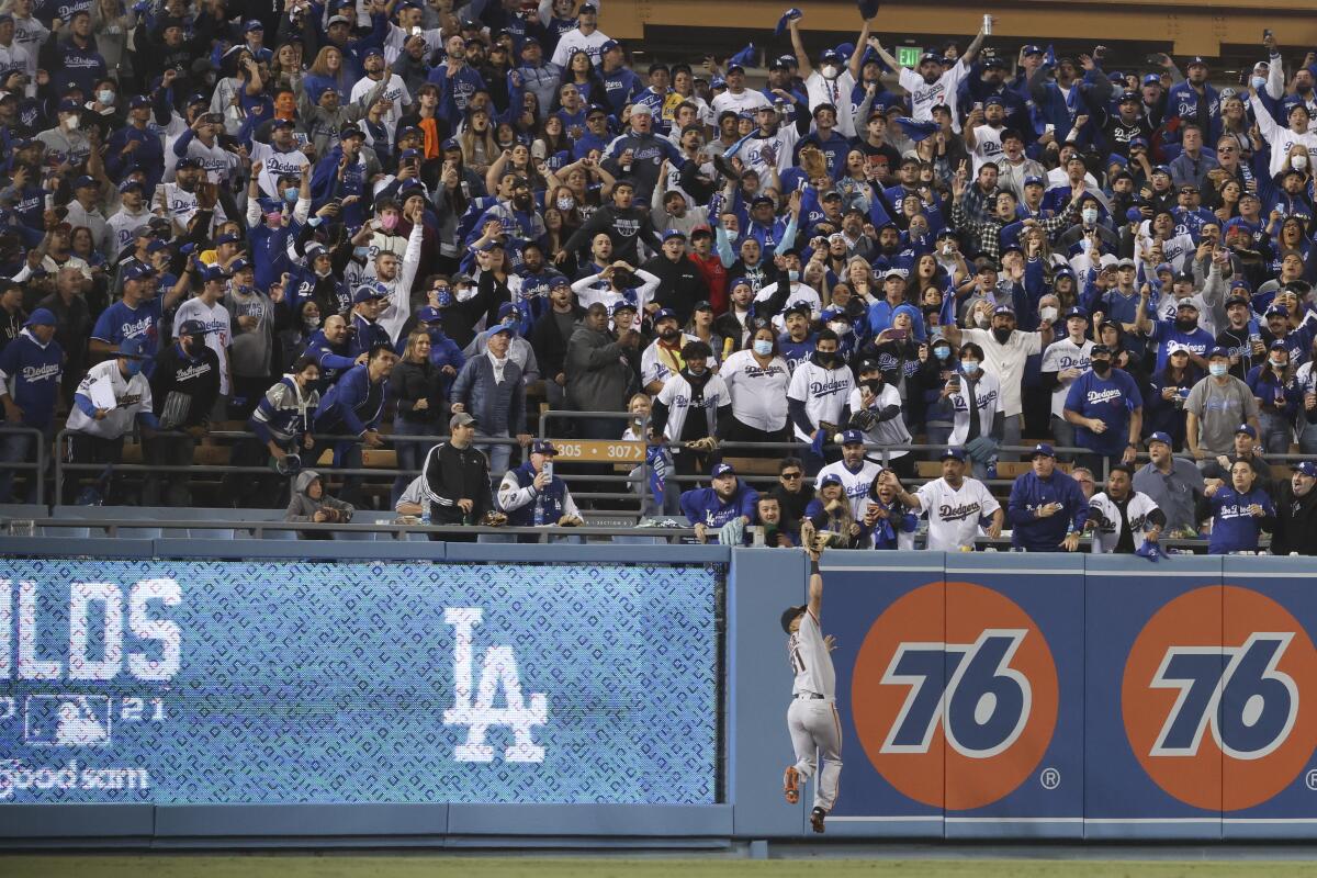 Giants left fielder LaMonte Wade Jr. makes a leaping catch on a fly ball hit by the Dodgers' Chris Taylor.