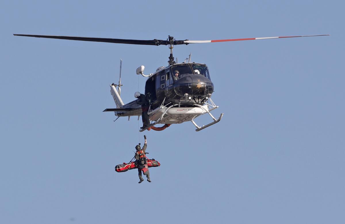 An Orange County Sheriff's Department helicopter crewman rescues a motorcycle rider.