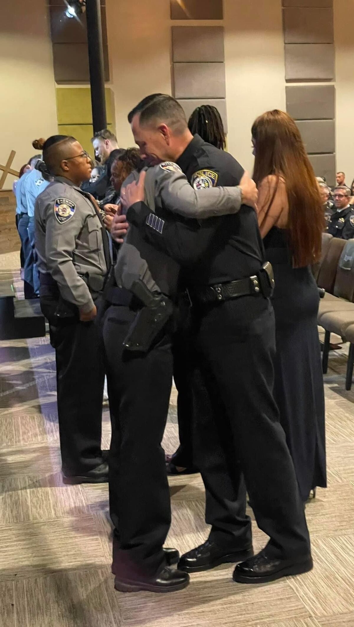 Escondido Police Sgt. Jeff Valdivia, right, gives a congratulatory hug to new El Paso County Sheriff's deputy Natalie Young.