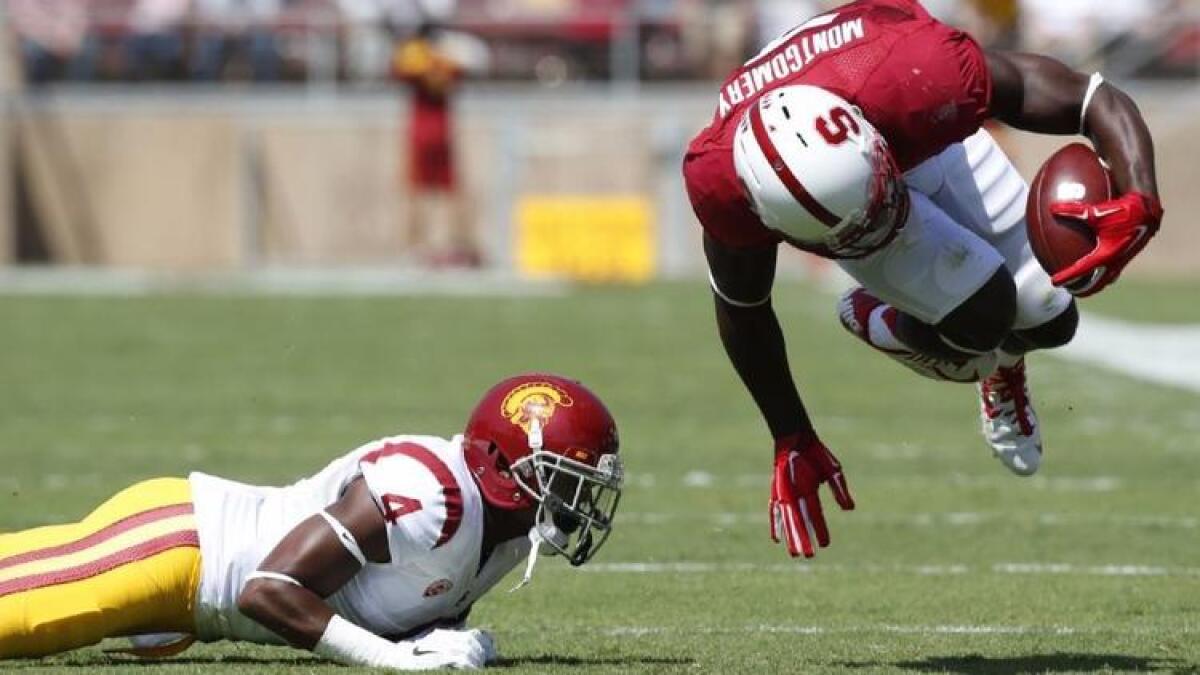 USC safety Chris Hawkins trips Stanford receiver Ty Montgomery for a short gain during a game at Stanford Stadium in 2014.