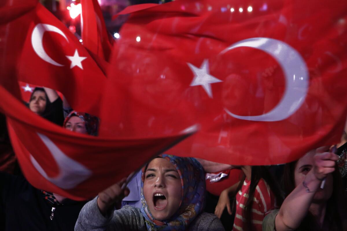 A crowd brandishes national flags and shouts slogans during an anti-coup rally in Istanbul in July.