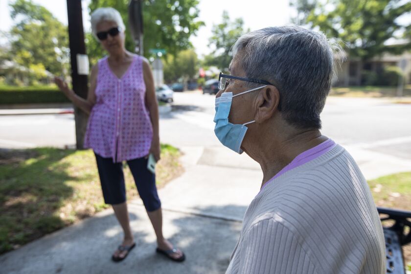 SOUTH PASADENA, CA - JULY 16: Mary Ann Maze, left, and Adriana Arroyo catch up with one another on Friday, July 16, 2021 in South Pasadena, CA. They are long time friends. Starting Saturday night, residents will again be required to wear masks in indoor public spaces, regardless of their vaccination status. Just a month ago, Los Angeles County and the rest of California celebrated a long-awaited reopening, marking the tremendous progress made in the battle against COVID-19 by lifting virtually all restrictions on businesses and other public spaces. Now, the coronavirus is resurgent, and the nation's most-populous county is scrambling to beat back the pandemic's latest charge.(Francine Orr / Los Angeles Times)