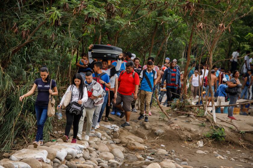 CÚCUTA, NORTE DE SANTANDER -- FRIDAY, MAY 17, 2019: Venezuelans cross the Colombia-Venezuela border from San Antonio del Táchira in Venezuela to Colombia through "trochas," illegal paths, near the Simón Bolívar International Bridge, on May 3, 2019 as seen from Cúcuta, Colombia, on May 17, 2019. (Marcus Yam / Los Angeles Times)