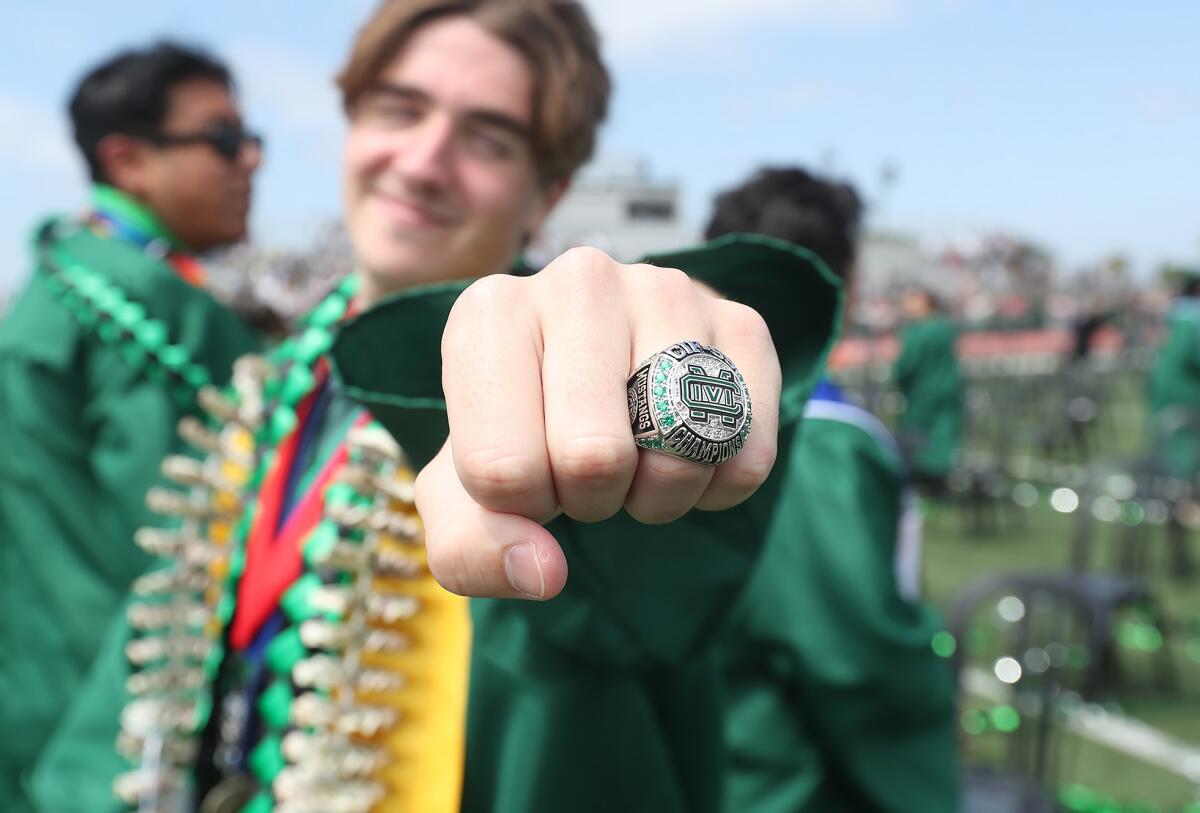 Decorated graduate Lucas Trask shows his CIF championship ring after graduating from Costa Mesa High school on Thursday.