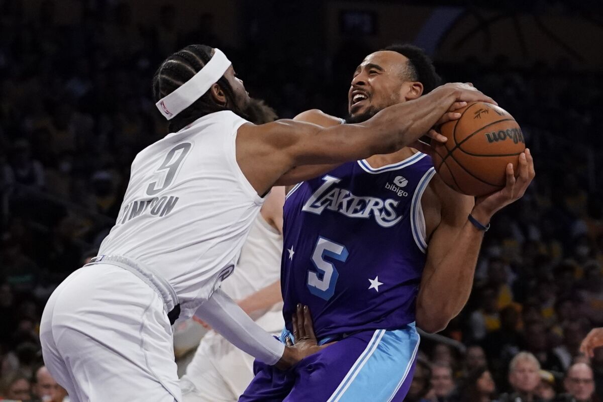 Oklahoma City Thunder guard Zavier Simpson (9) fouls Los Angeles Lakers guard Talen Horton-Tucker (5) during the first half of an NBA basketball game in Los Angeles, Friday, April 8, 2022. (AP Photo/Ashley Landis)
