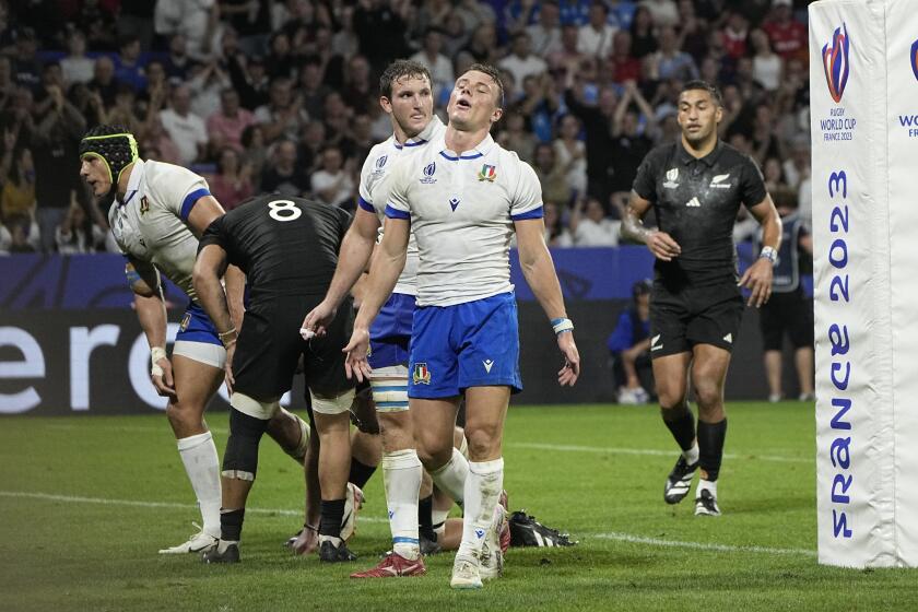 Italy's Paolo Garbisi, center, reacts after a try from New Zealand during the Rugby World Cup Pool A match between New Zealand and Italy at the OL Stadium in Lyon, France, Friday, Sept. 29, 2023. (AP Photo/Laurent Cipriani)