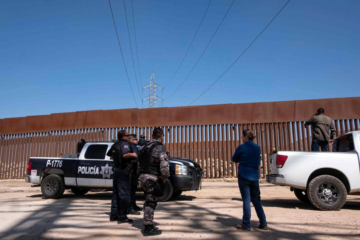 Mexican security forces patrol the U.S.-Mexico border fence