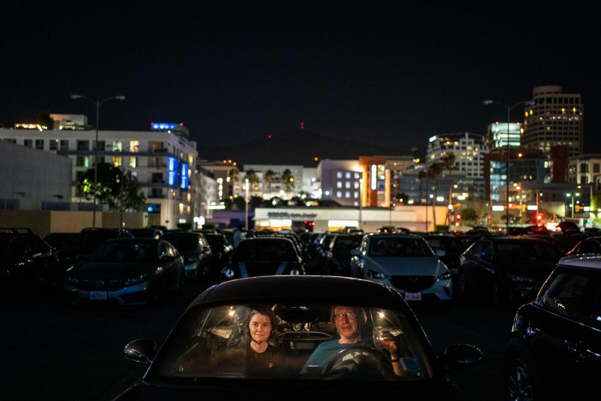 Elsbeth Steele and Chris Williams watch a movie at the Electric Dusk Drive-in atop a former Sears parking garage in Glendale.