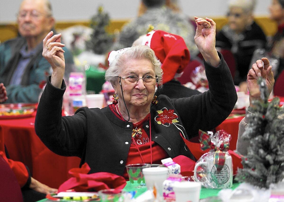Betty Williams dances at her table during the Costa Mesa Senior Center's annual Christmas party. The center was also celebrating its reopening after renovations.