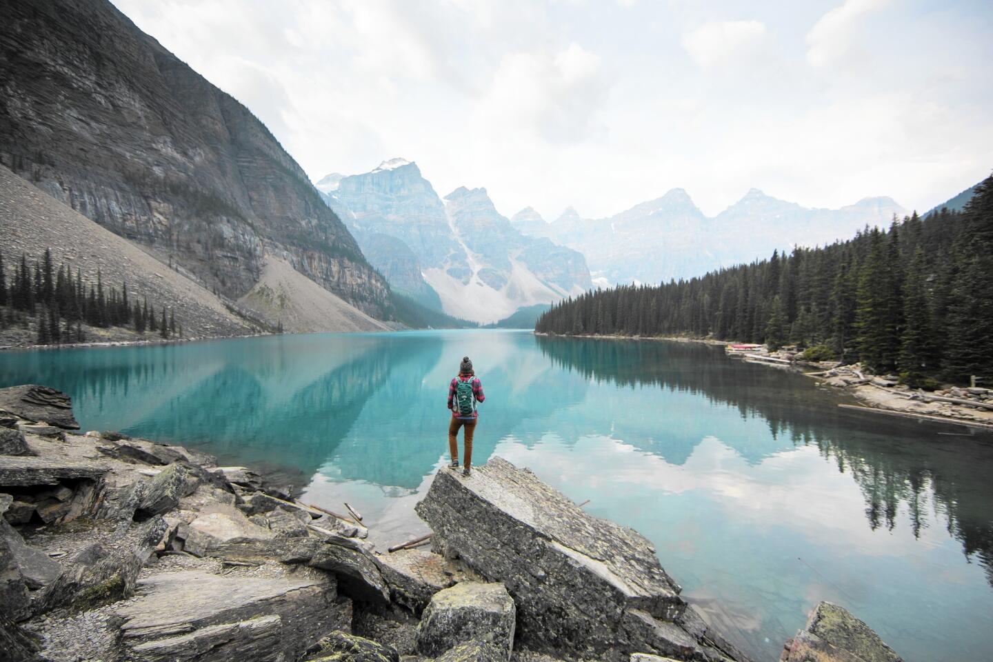 A woman looks out over Moraine Lake in Alberta, Canada.