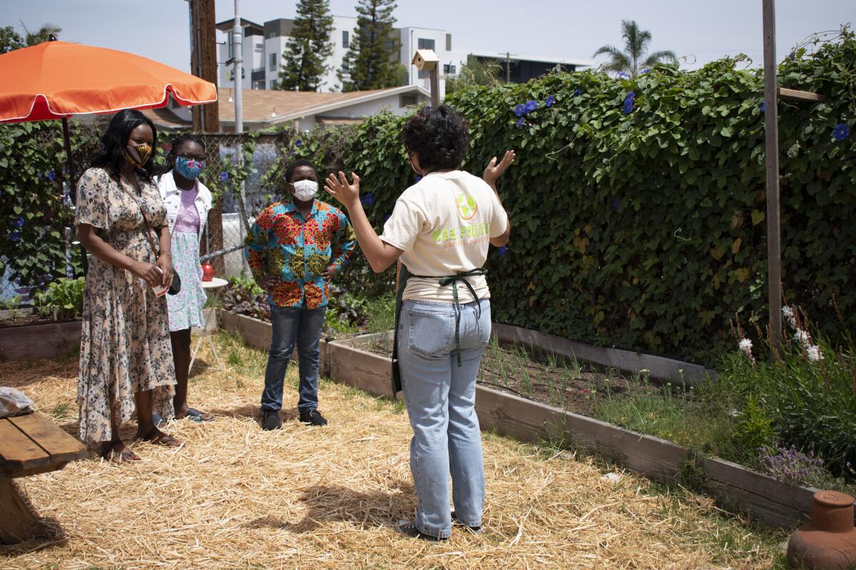 Fernanda Siordia, participante en el programa Youth FarmWorks de MAKE Projects, dando un recorrido por el jardín 

