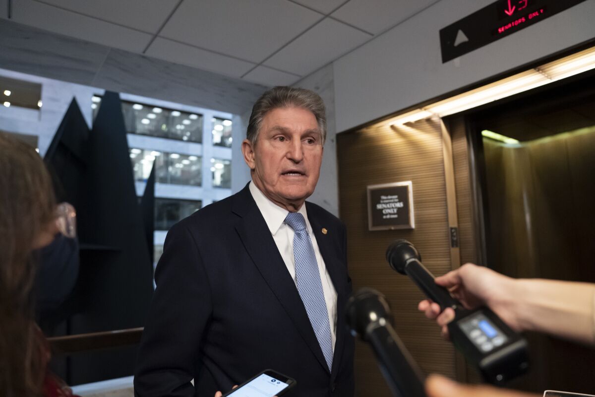 FILE - Sen. Joe Manchin, D-W.Va., leaves his office after speaking with President Joe Biden about his long-stalled domestic agenda, at the Capitol in Washington, Dec. 13, 2021. Manchin said Tuesday, Jan. 4, 2022, that his opposition to President Joe Biden's roughly $2 trillion package of social and environmental initiatives remains undimmed, as party leaders said work on the stalled measure was on hold until at least later this month. (AP Photo/J. Scott Applewhite, File)