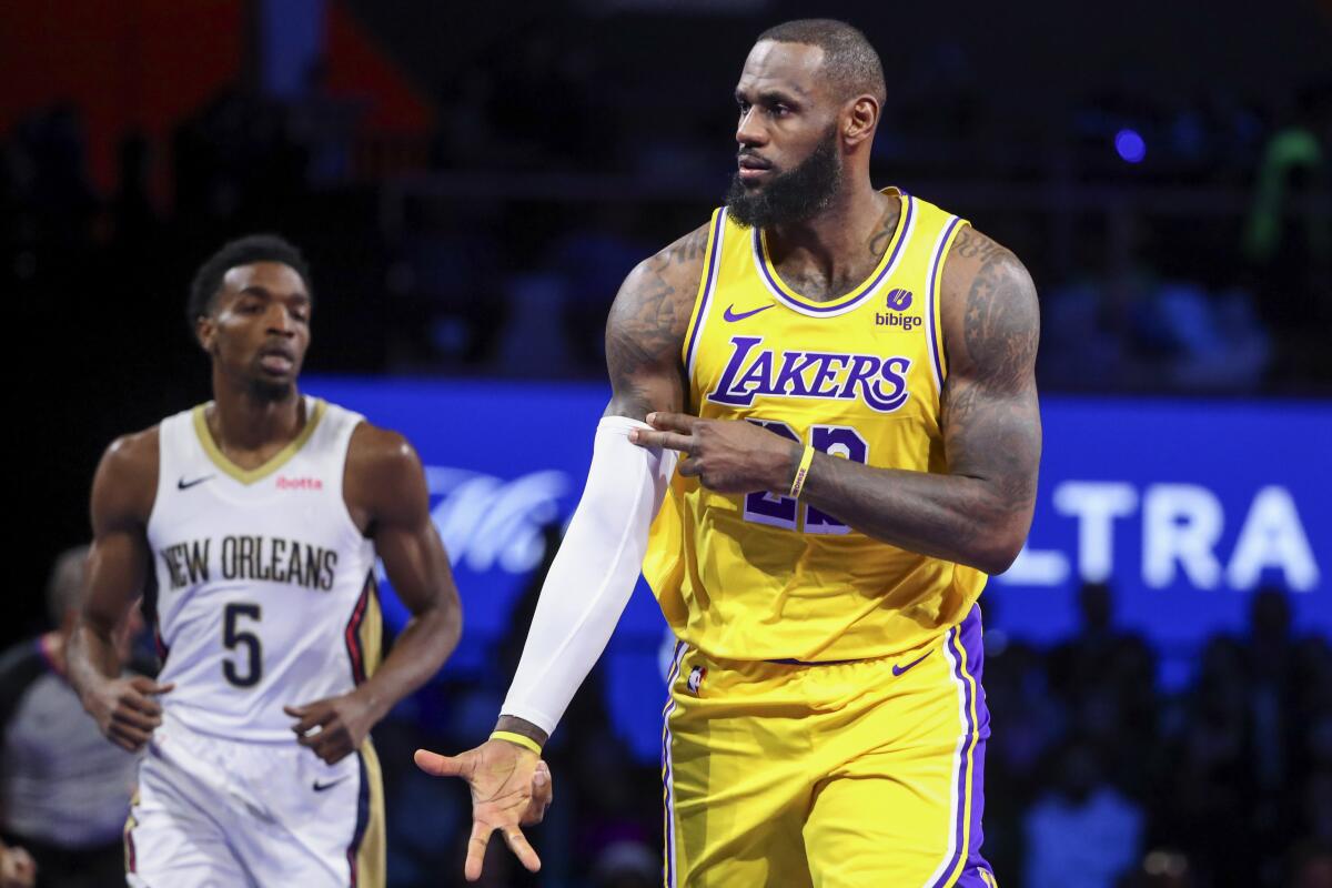 Lakers forward LeBron James flashes his team's sign for making a three-point basket.