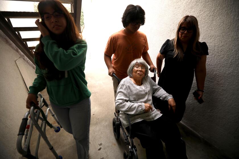 NORTHRIDGE, CA - SEPTEMBER 11, 2023 - Rosa Angelica Saldana, 81, in wheelchair, is helped home by her grandchildren Paola Rojas, 19, from left, her brother Max Rojas, 14, and their mother Mariella Rojas in Northridge on September 11, 2023. Saldana, who suffers from dementia, lives with her daughter Mariella and her family in a three bedroom apartment. Max and Paola, share a bedroom so their grandmother has a space of her own. Saldana has lived with her family for the past seven years. As the population ages, and costs of care becoming crippling, many families, like the Rojas family, take care of an elder family member themselves out of cultural tradition and financial necessity. (Genaro Molina / Los Angeles Times)