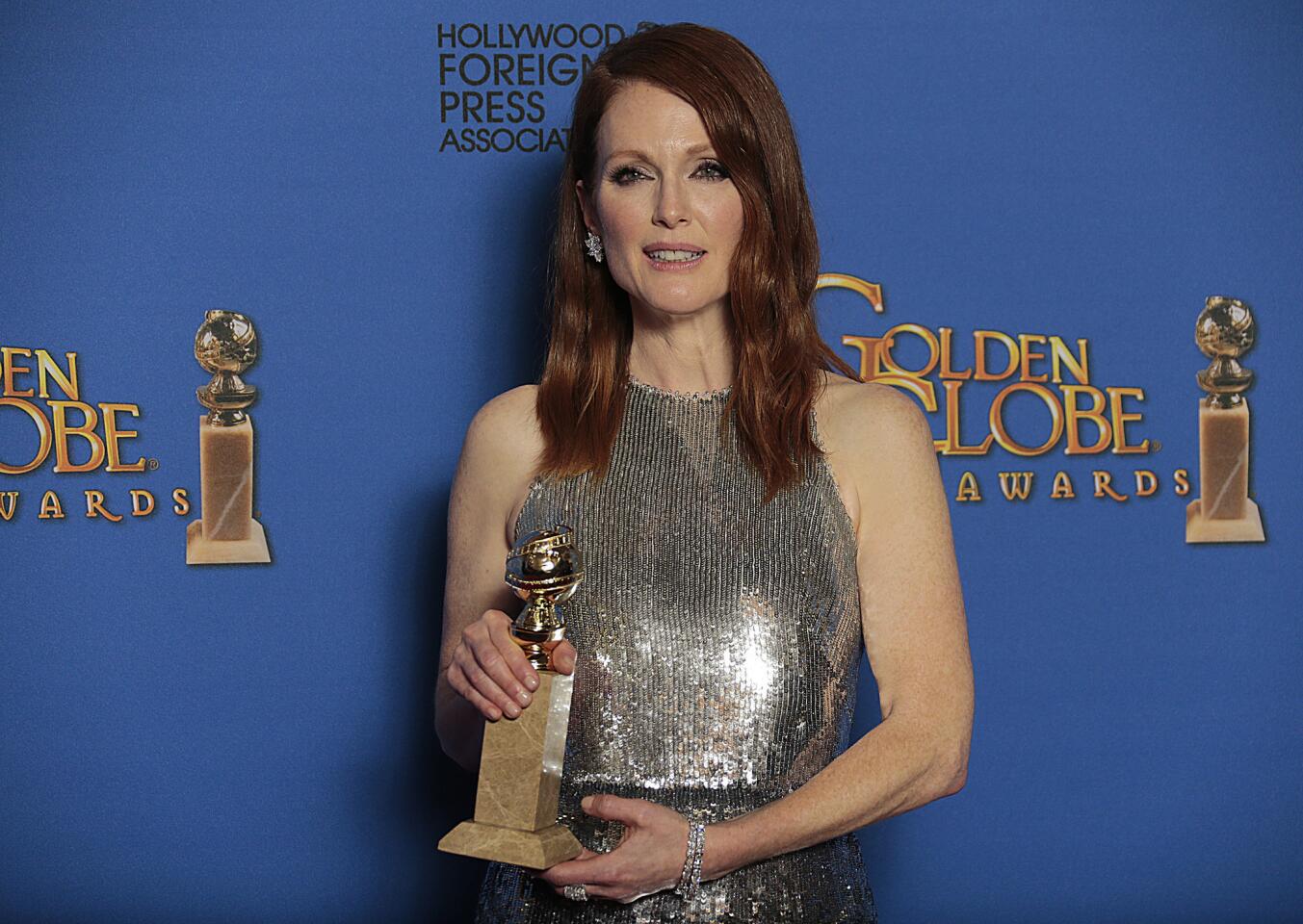Julianne Moore displays her award for lead actress in a film drama for "Still Alice" backstage at the 72nd Golden Globe Awards.