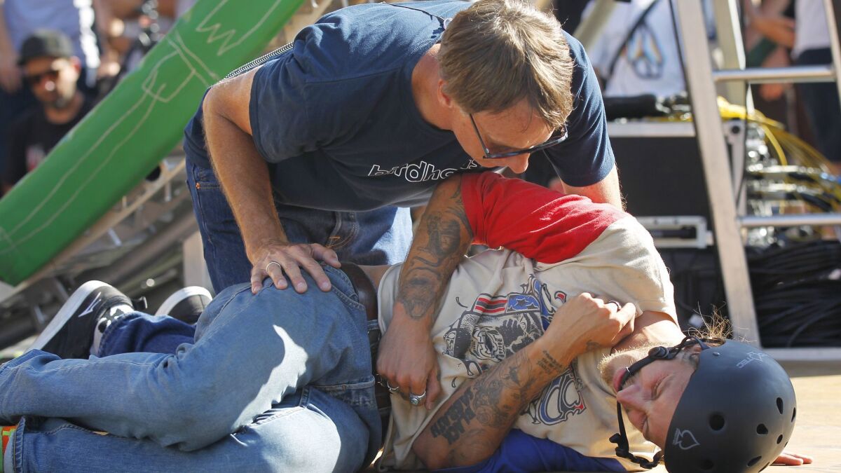 Tony Hawk checks on his son, Riley, who fell attempting the Loop Challenge Live in Vista on Suunday.