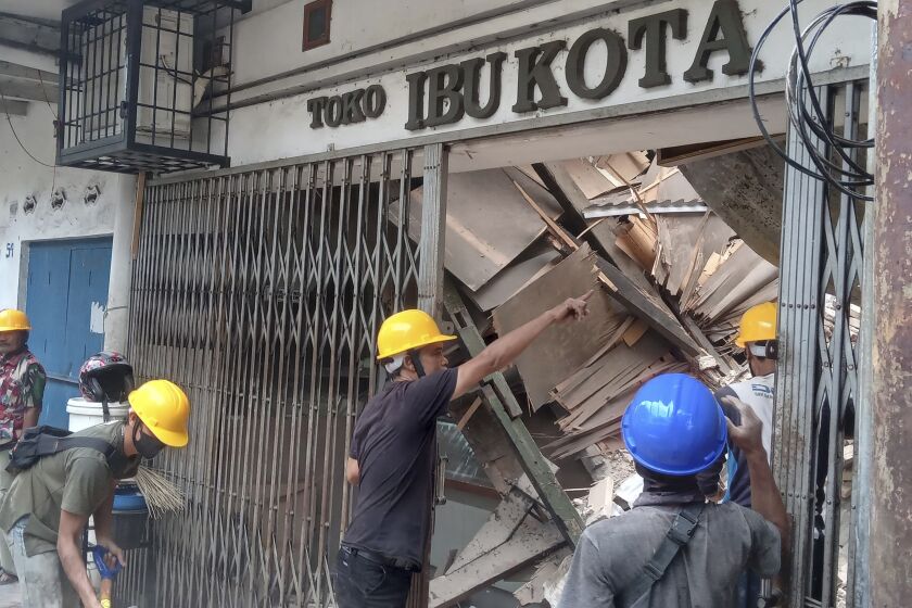 Trabajadores inspeccionan una tienda dañada durante un sismo en Cianjur, Java Occidental Indonesia, el lunes 21 de noviembre de 2022. (AP Foto/Firman Taqur)