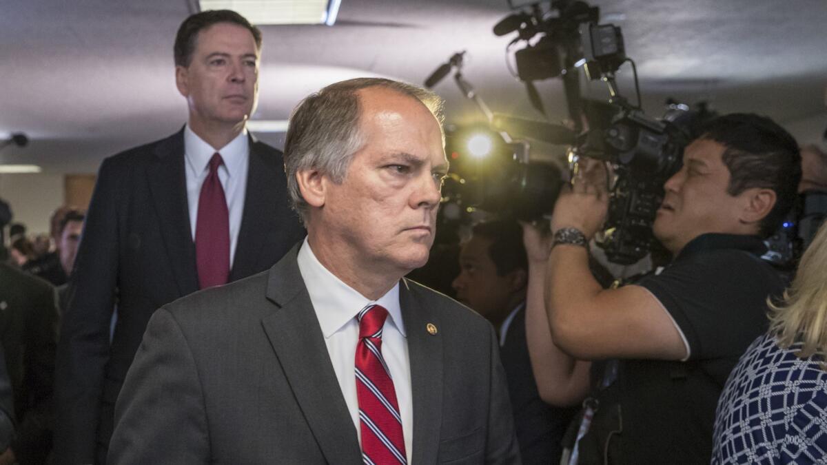 James Wolfe, former director of security for the Senate Intelligence Committee, shown in 2017 with former FBI Director James B. Comey. Federal prosecutors accuse Wolfe of lying to the FBI about contacts he had with reporters.