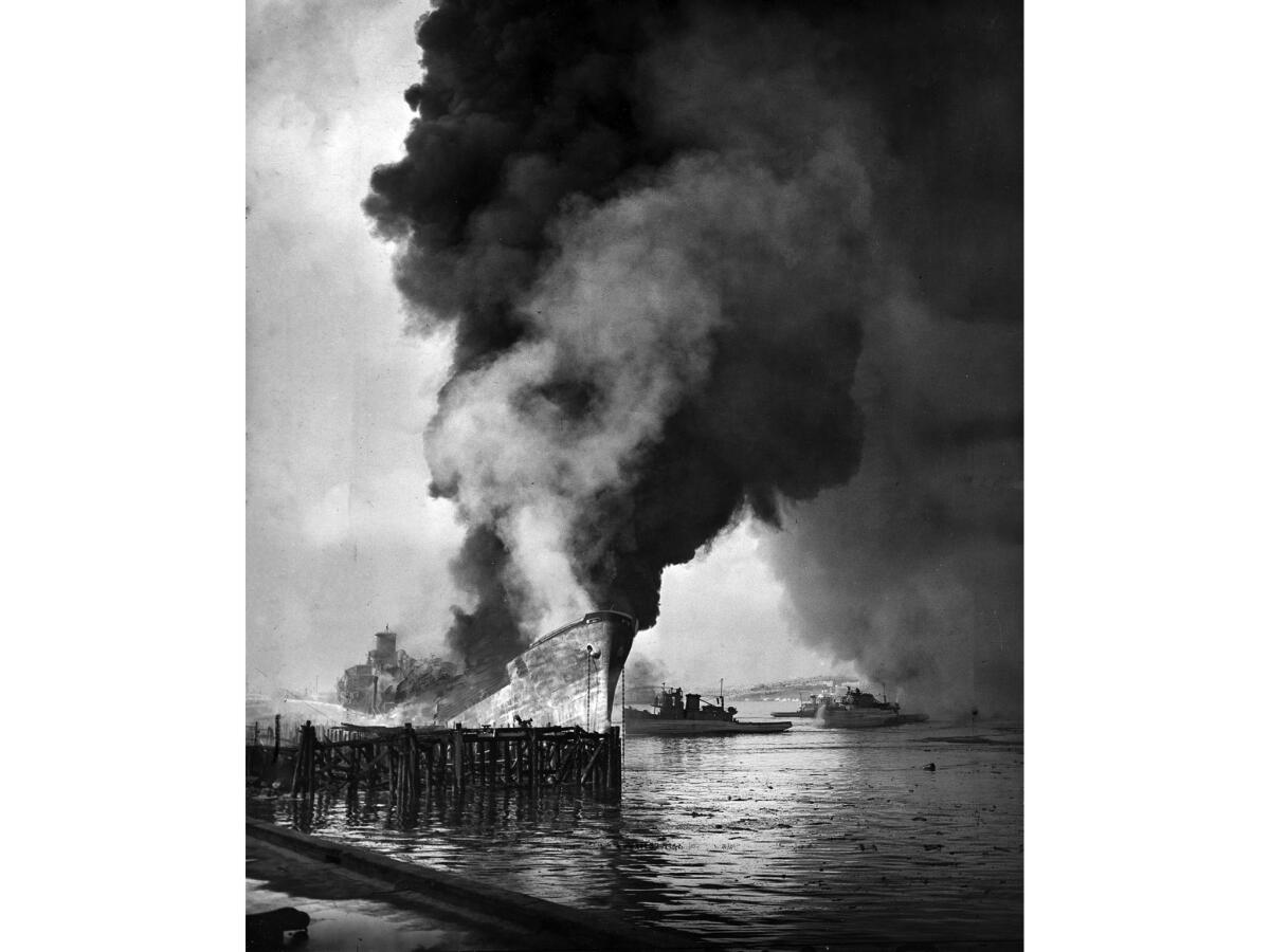 June 22, 1947: The remains of the tanker Markay burn at Los Angeles Harbor following explosions.