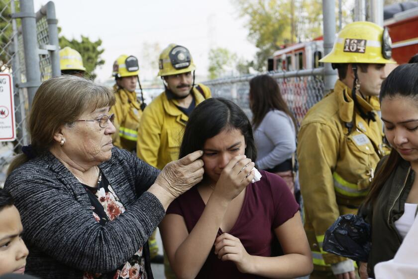 Student Marianna Torres, 11, center, cries as she evacuates Park Avenue Elementary School after jet fuel fell on the school in Cudahy, Calif., Tuesday, Jan. 14, 2020. Jet fuel dumped by an aircraft returning to Los Angeles International Airport fell onto the school playground where children were playing Tuesday, fire officials said. The Los Angeles County Fire Department said firefighters assessed over a dozen children and several adults who complained of minor injuries and none needed to be taken to a hospital. (AP Photo/Damian Dovarganes)