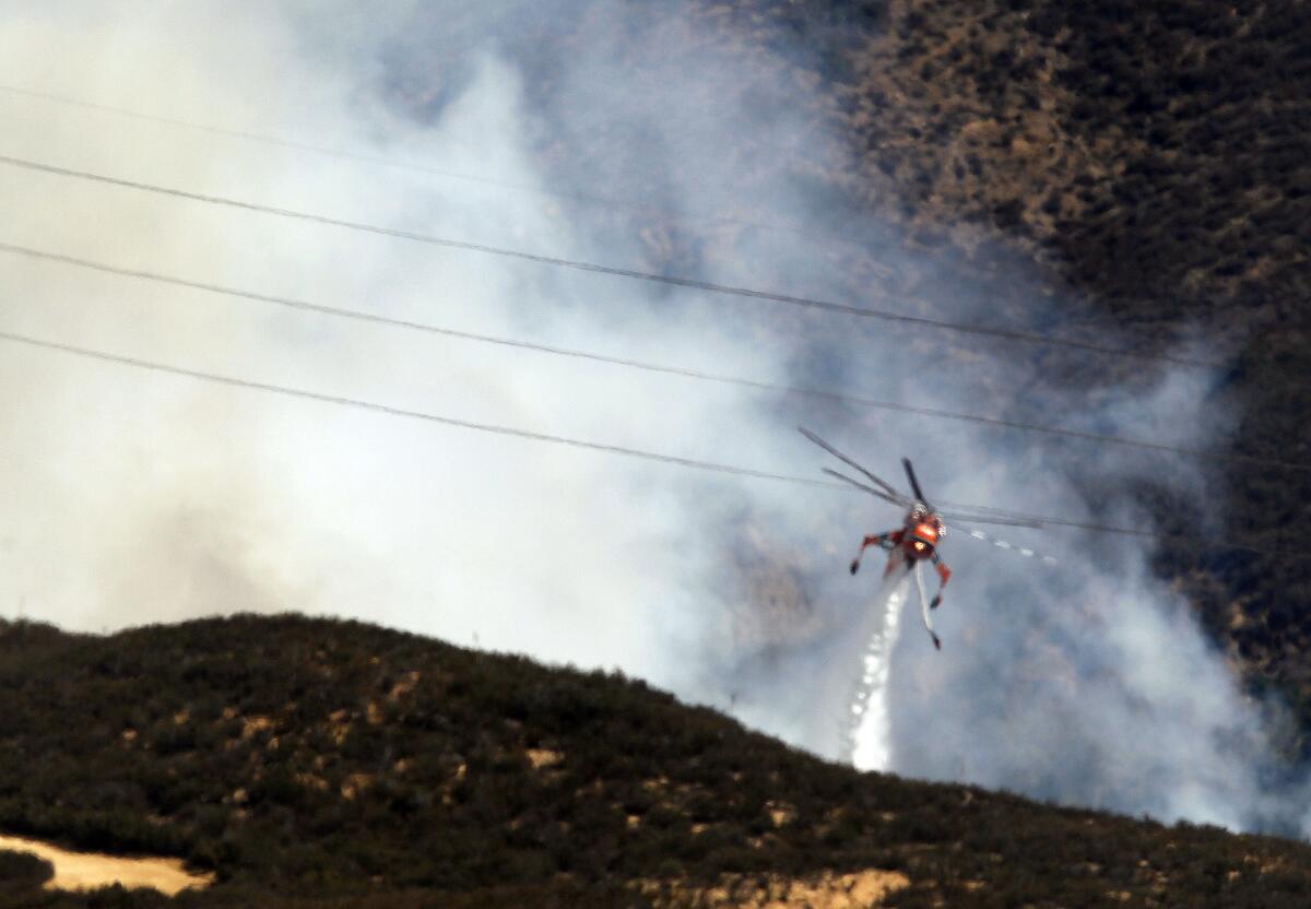 A helicopter drops water on the so-called Baker fire in Orange County near the Cleveland National Forest.