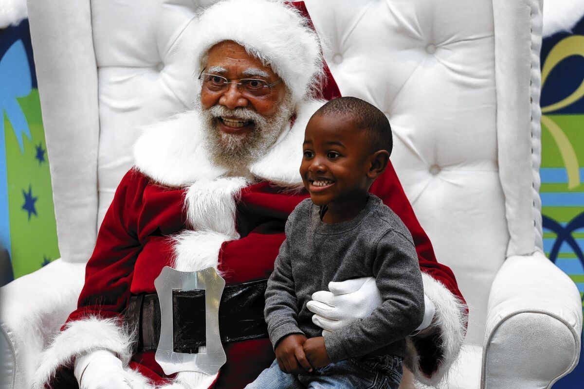 Jahleel Logan, 3, poses with Santa Claus, a.k.a. Langston Patterson, 77