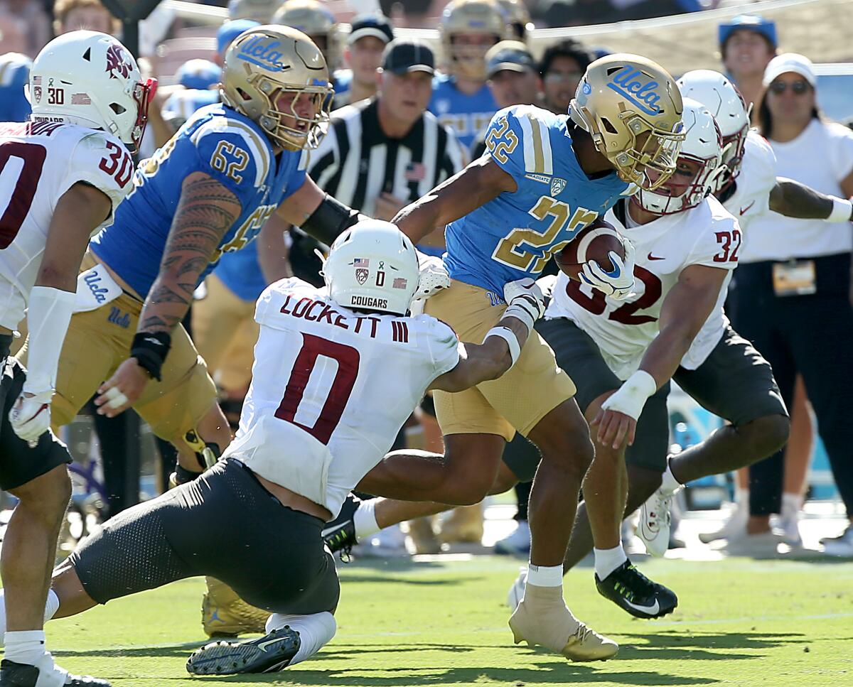 UCLA wide receiver Keegan Jones breaks a tackle by Washington State defensive back Sam Lockett III.
