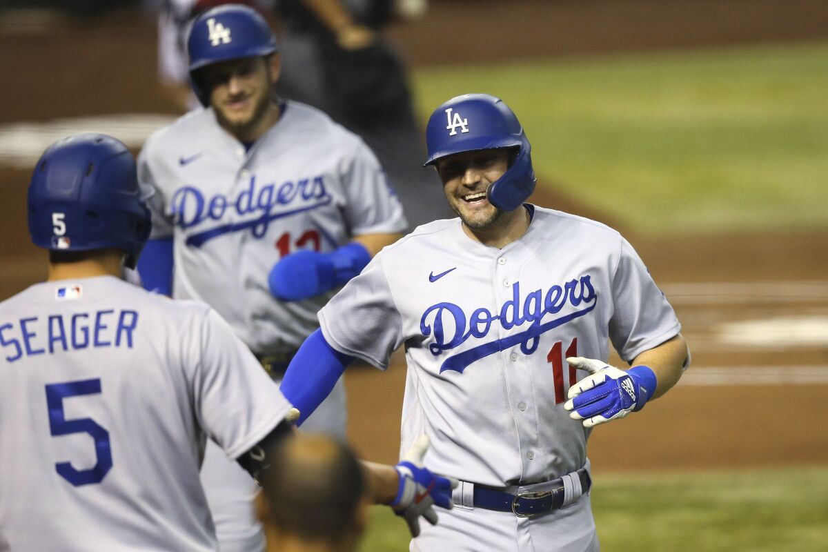 Dodgers outfielder AJ Pollock celebrates with teammate Corey Seager after hitting a two-run home run
