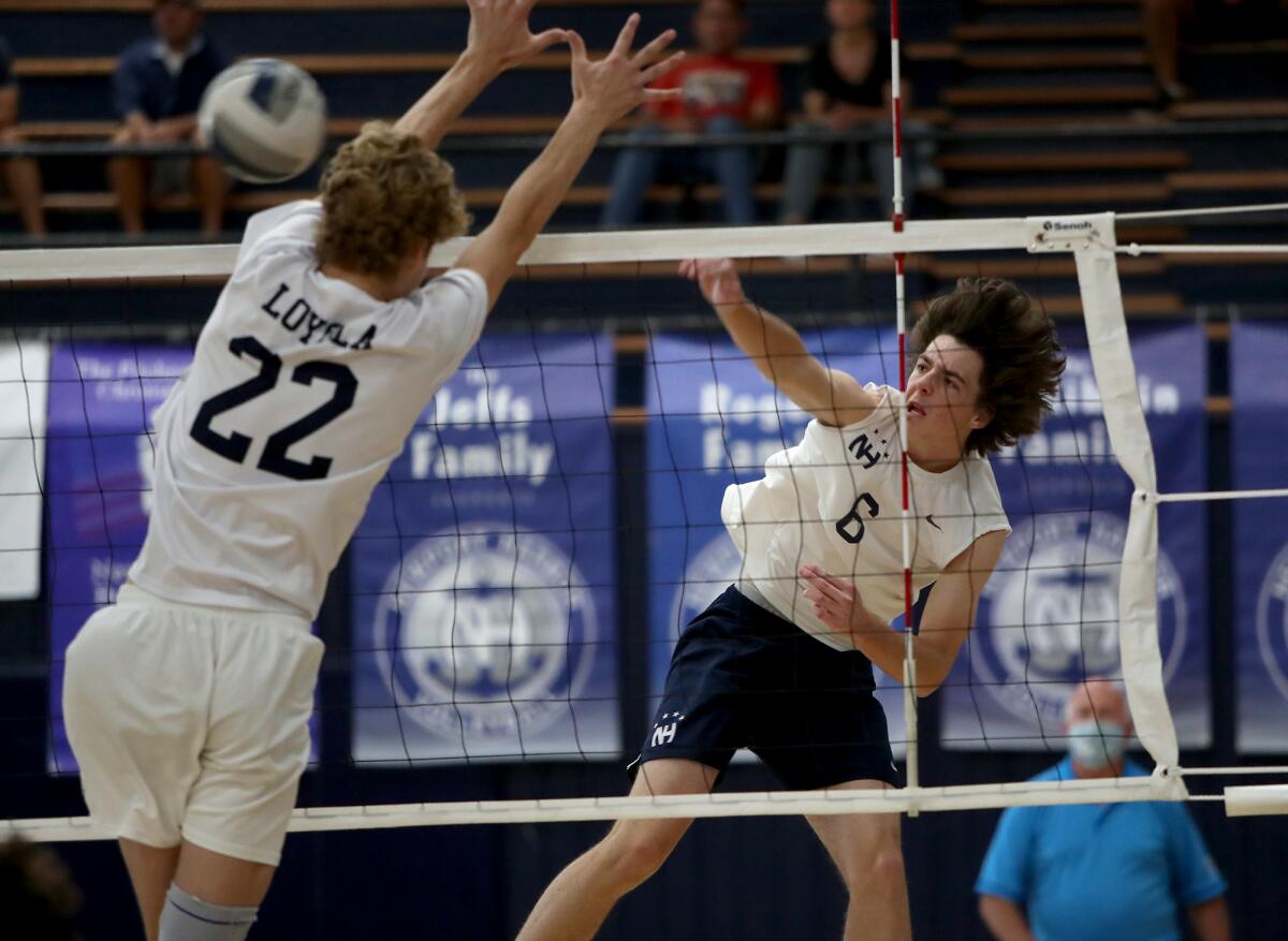 Newport Harbor's Jake Read (6) spikes the ball against Los Angeles Loyola's Cooper Robinson (22) during the first set.