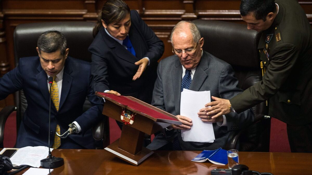 Peruvian President Pedro Pablo Kuczynski, seated right, collects his notes after delivering a speech to the Congress on Thursday in Lima alongside President of the Congress Luis Galarreta.