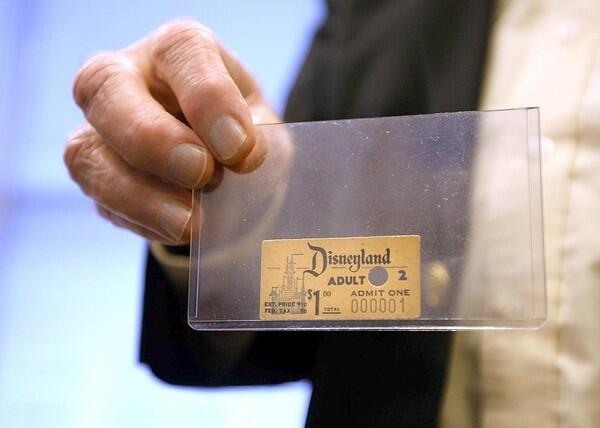 Disney archivist Dave Smith holds the first Disneyland admission ticket ever sold. The ticket was purchased by Roy O. Disney.
