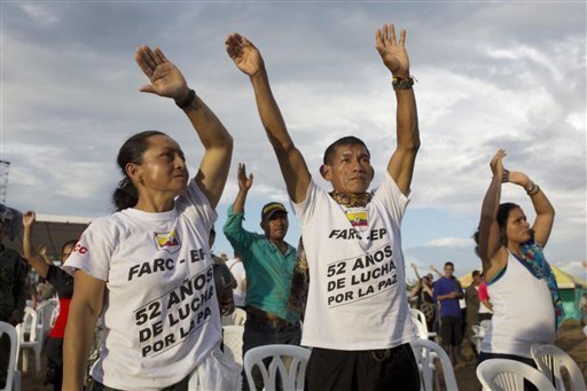 Rebeldes de las Fuerzas Armadas Revolucionarias de Colombia hacen la ola en Sabanas del Yarí, Colombia, mientras ven imágenes en directo en las pantallas de la firma del acuerdo de paz entre el gobierno y las FARC en Cartagena para poner fin a más de cinco décadas de hostilidades, el lunes 26 de septiembre del 2016. En sus camisetas se lee: “52 años de lucha por la paz".