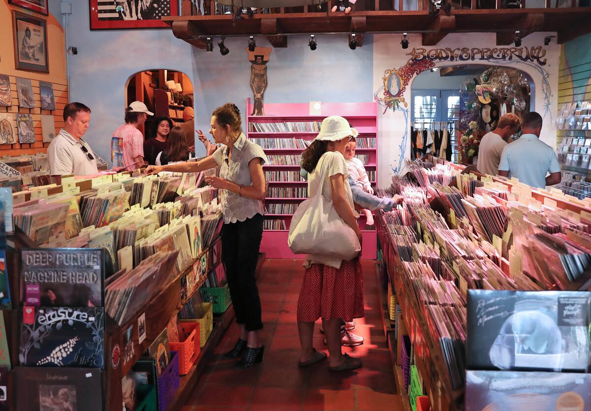 Guests pore through musical offerings at Sound Spectrum, a record store reopening in Laguna Beach.