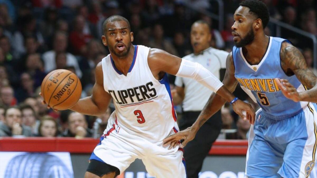 Clippers guard Chris Paul tries to dribble around Nuggets guard Will Barton during a game on Dec. 20.