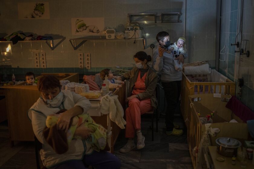 Hospital staff take care of orphaned children at the children's regional hospital maternity ward in Kherson, southern Ukraine, Tuesday, Nov. 22, 2022. Throughout the war in Ukraine, Russian authorities have been accused of deporting Ukrainian children to Russia or Russian-held territories to raise them as their own. At least 1,000 children were seized from schools and orphanages in the Kherson region during Russia’s eight-month occupation of the area, their whereabouts still unknown. (AP Photo/Bernat Armangue)
