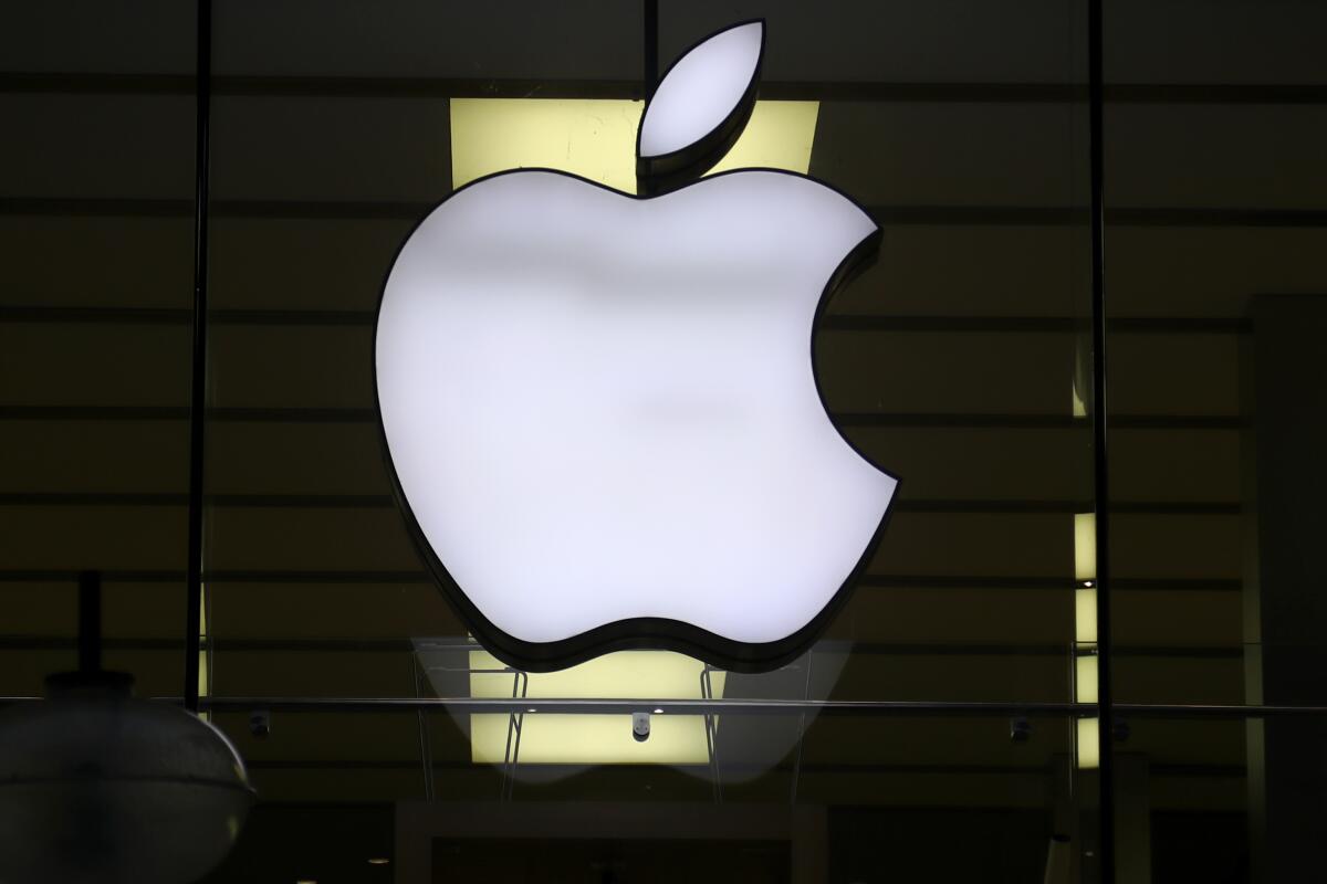 The logo of Apple is illuminated at a store in the city center in Munich, Germany. 