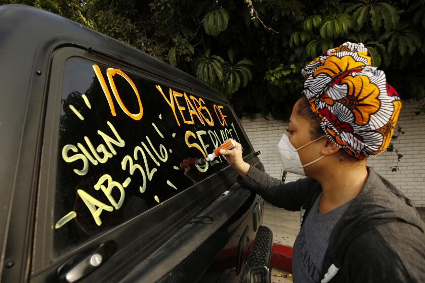 LOS ANGELES , CA - SEPTEMBER 22: Courtney Banks who has worked in events and catering at the Chateau Marmont writes message on windows of vehicles in support of workers who lost their jobs at the Chateau Marmont and are forming a caravan of hotel workers as they travel from the LA area to Sacramento to protest in favor of a bill that would protect their jobs. Hotel workers from around Southern California join workers at the Chateau Marmont on Sunset Blvd Tuesday morning where they picketed to drivers passing's on Sunset Blvd. Several hotels are cutting operations because of the financial effects of the COVID-19 crisis. Chateau Marmont on Tuesday, Sept. 22, 2020 in Los Angeles , CA. (Al Seib / Los Angeles Times