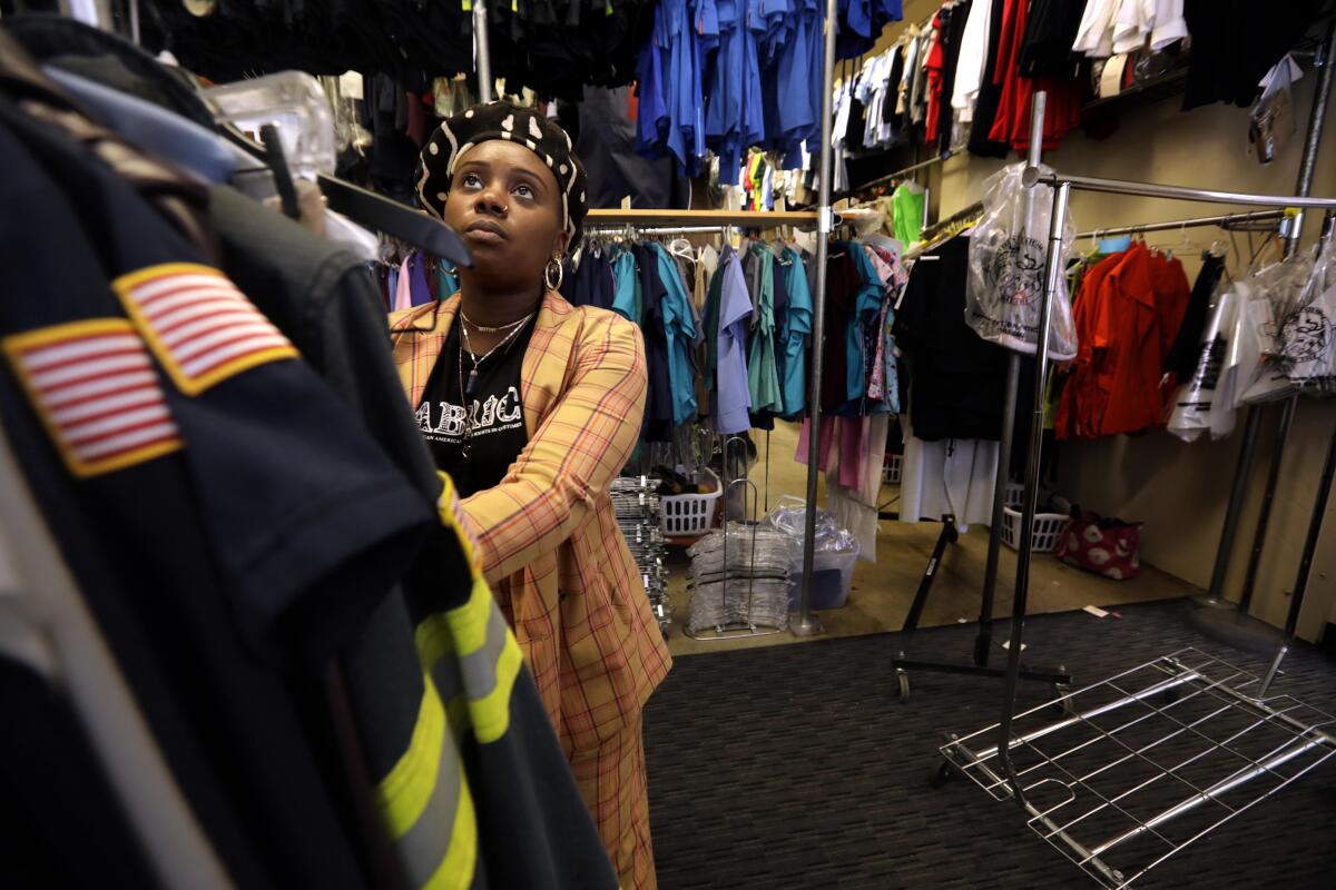 A costumer pushes a rack of clothes.