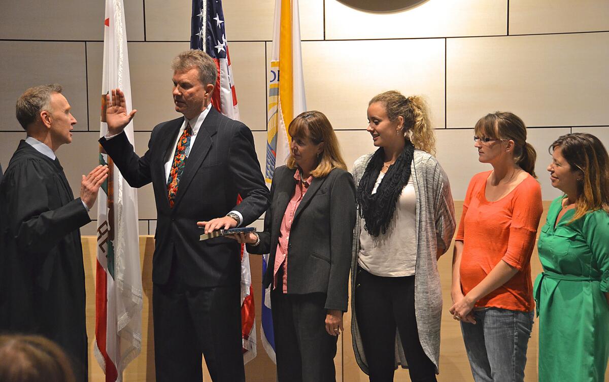 Judge James E. Rogan swears in Scott Peotter after his election to the Newport Beach City Council last year.