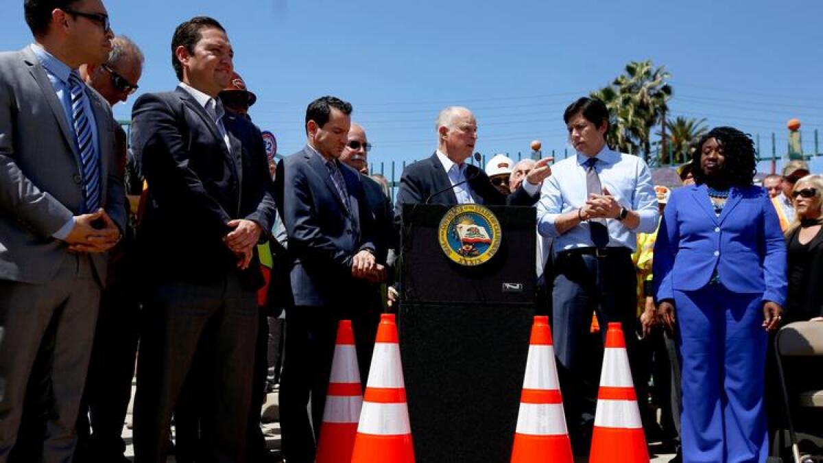 Gov. Jerry Brown, at lectern, speaks in favor of the gas tax increase with Assembly Speaker Anthony Rendon (D-Paramount), left of Brown, and state Senate leader Kevin de Léon in April.