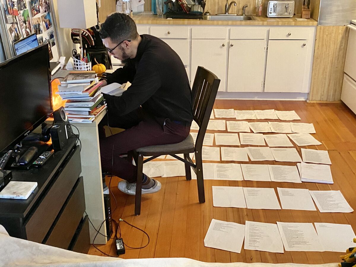 Lakayana Drury works on his autobiographical poetry manuscript, arranged on the floor of his Portland, Ore., apartment.