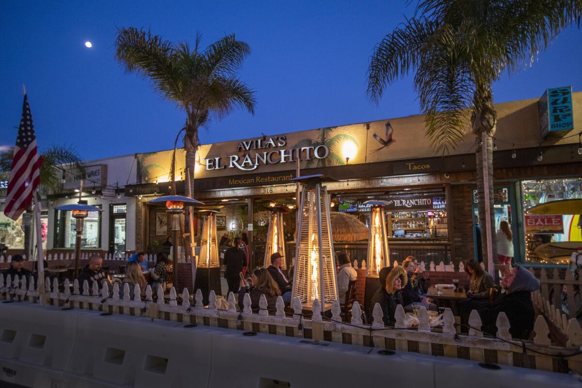People dine outdoors along Main Street in Huntington Beach.