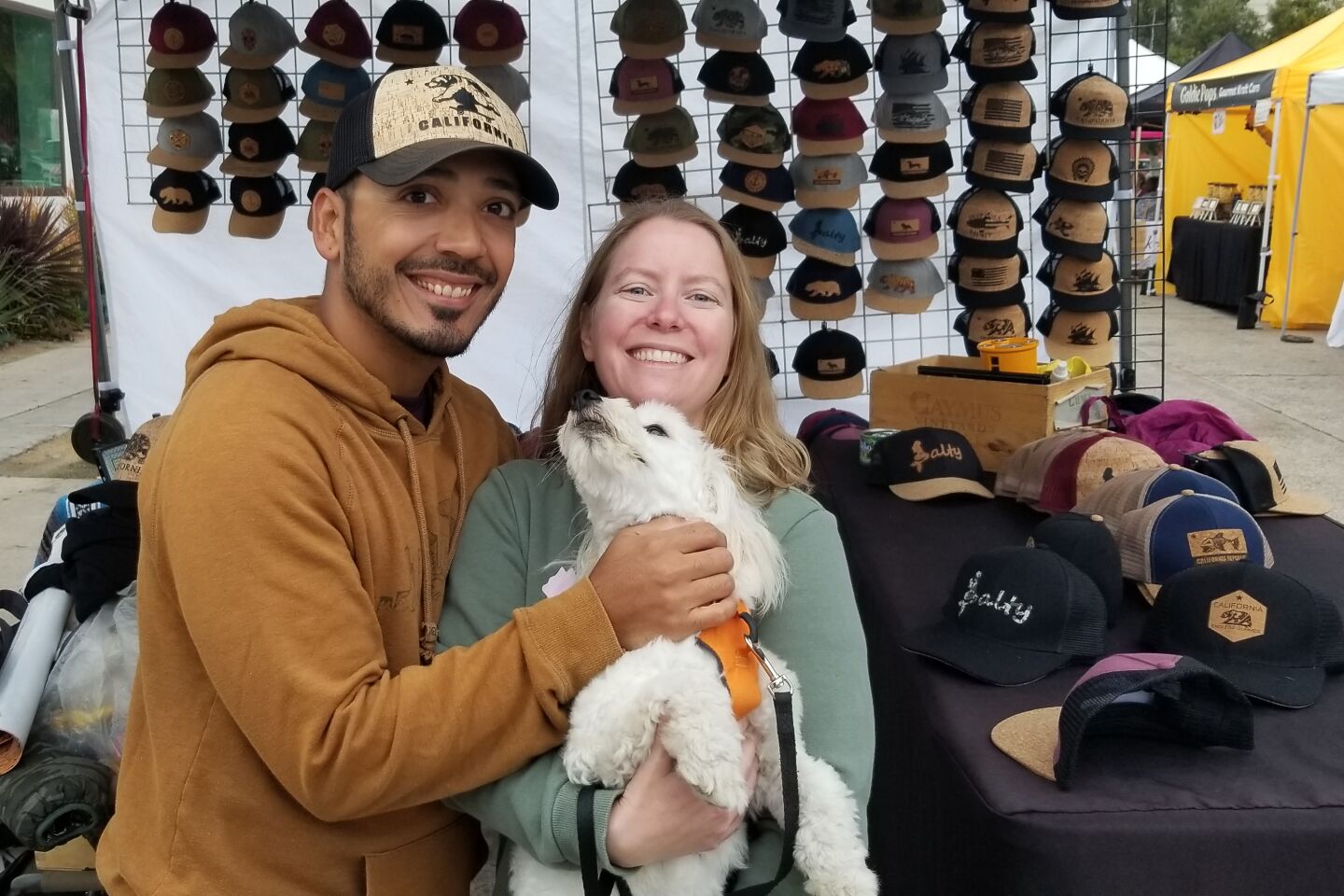 Jesus Medina tries on hats while he and Melissa Rose try to wrangle Toby into smiling for the camera.